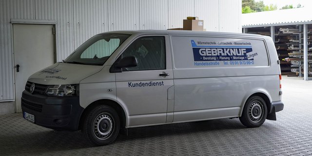Der Lieferwagen ist mit Informationen über Heizungs- und Sanitärtechnik beschriftet und parkt in einem geschlossenen Raum.