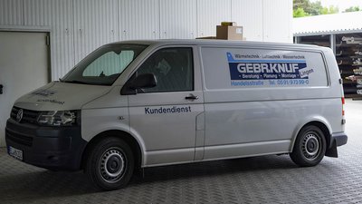 Servicefahrzeug für Heizungs- und Sanitärtechnik im Einsatz Der Lieferwagen ist mit Informationen über Heizungs- und Sanitärtechnik beschriftet und parkt in einem geschlossenen Raum.