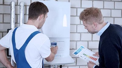 Zwei Maenner die an einer Heizung stehen 